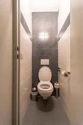 a bathroom with a white toilet in a stall at Hotel Ambiotel in Tongeren