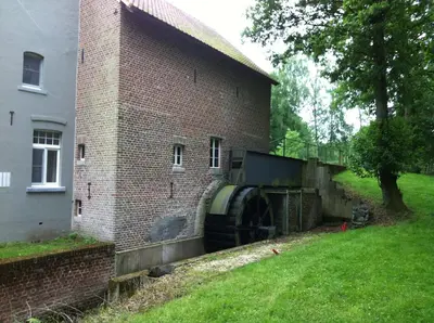 a brick building with a large water tank next to it at De Oude Molen in As
