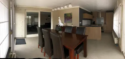 a dining room with a wooden table and chairs at Vivere in Houthalen-Helchteren