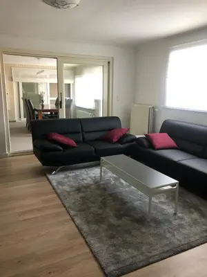 a living room with a black couch and a coffee table at Vivere in Houthalen-Helchteren