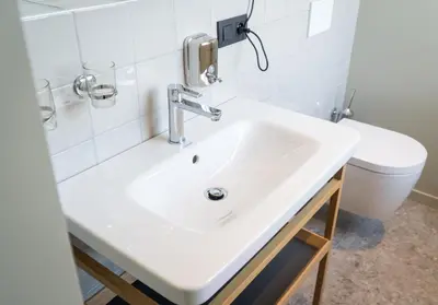 a bathroom with a white sink and a toilet at Café Coureur Borgloon in Borgloon