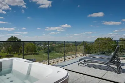 a bathroom with a tub and a bench on a balcony at Café Coureur Borgloon in Borgloon
