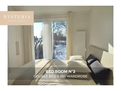 a bedroom with a bed in front of a window at Wisteria Guest House in Villers-lʼÉvêque
