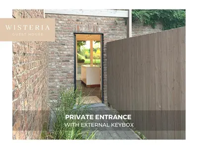 a entrance to a brick building with a fence at Wisteria Guest House in Villers-lʼÉvêque
