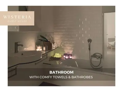 a bathroom with a sink and a bath tub with candles at Wisteria Guest House in Villers-lʼÉvêque