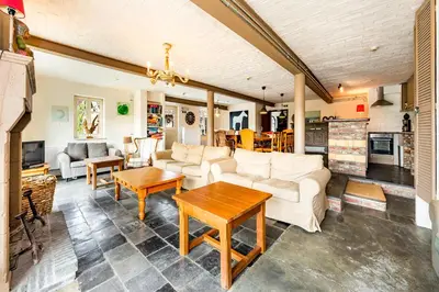 a living room with white furniture and a fireplace at De Appelgaard in Sint-Martens-Voeren