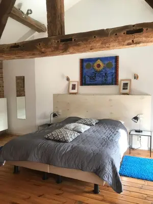 a bedroom with a bed and a blue rug at B&B De Henehoeve in Heks