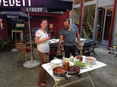 a man and a woman standing next to a table with food at B&B De Henehoeve in Heks