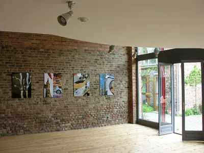 a brick wall with a bunch of pictures on it at B&B De Henehoeve in Heks