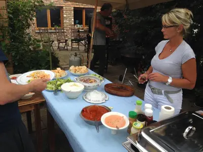 a woman standing in front of a table with food at B&B De Henehoeve in Heks