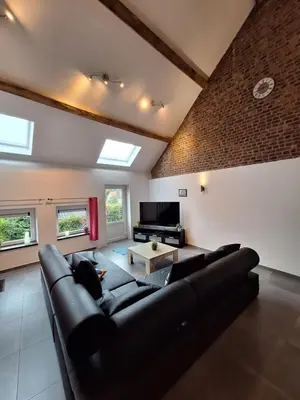 a living room with a couch and a tv at Gîte Cour Delhez in Olne