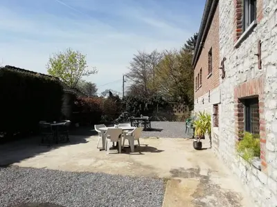 a patio with a table and chairs next to a building at Gîte Cour Delhez in Olne