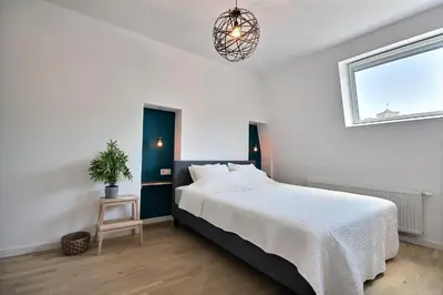 a bedroom with a bed and a potted plant at Gats Place in Liège
