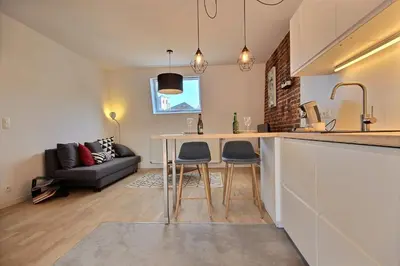 a kitchen with a table and two chairs in a room at Gats Place in Liège