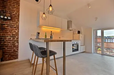 a kitchen with a bar with two stools at Gats Place in Liège