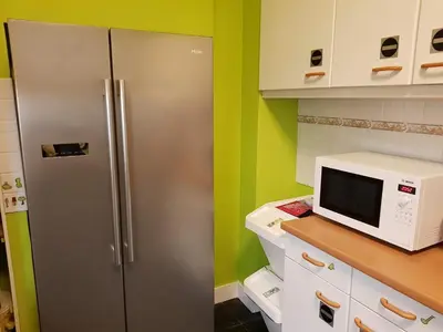 a kitchen with a stainless steel refrigerator and a microwave at Espace Douffet - Un havre de paix en pleine ville in Liège