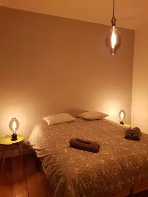 a bedroom with a bed with two lamps on it at Espace Douffet - Un havre de paix en pleine ville in Liège