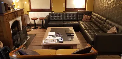 a living room with a leather couch and a coffee table at Espace Douffet - Un havre de paix en pleine ville in Liège