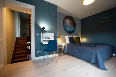 a bedroom with a bed and a desk with a chair at B&B Gaudium XII in Tongeren