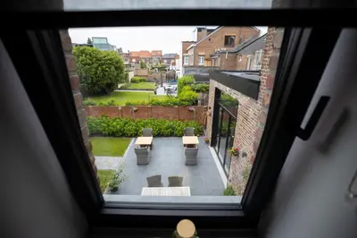 a view from a window of a courtyard with benches at B&B Gaudium XII in Tongeren