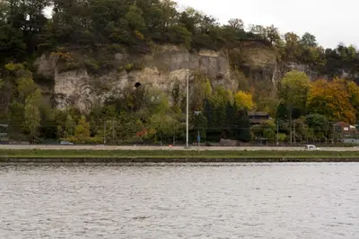 a large mountain next to a body of water at Hôtel Mosa in Hermalle-sous-Argenteau