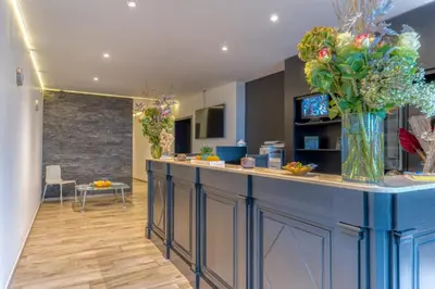 a lobby with a counter with a vase of flowers at Hôtel Mosa in Hermalle-sous-Argenteau
