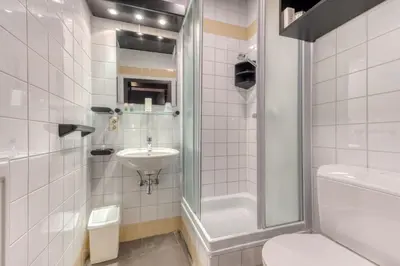 a bathroom with a shower sink and a toilet at Hôtel Mosa in Hermalle-sous-Argenteau