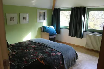 a bedroom with a bed and two windows at Beau Reg'Art in Hasselt