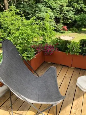 a chair sitting on a wooden deck with flowers at Beau Reg'Art in Hasselt