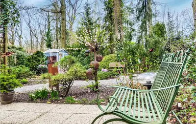 a green bench sitting in the middle of a garden at Beautiful Home In Rekem-Lanaken in Bovenwezet