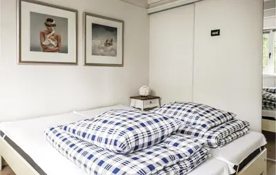a bedroom with a bed with checkered pillows at Beautiful Home In Rekem-Lanaken in Bovenwezet