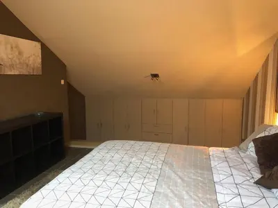 a bedroom with a large bed in a attic at Gastenverblijf 't Princenhuis in Vechmaal