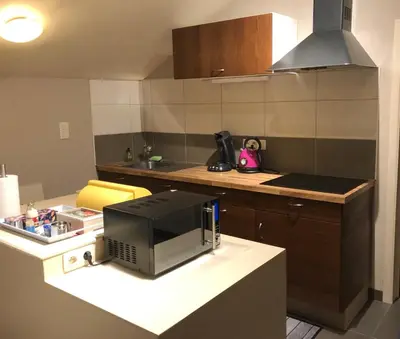 a small kitchen with a microwave on a counter at Gastenverblijf 't Princenhuis in Vechmaal