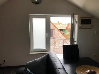 a living room with a couch and a large window at Gastenverblijf 't Princenhuis in Vechmaal