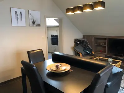 a living room with a black table and chairs at Gastenverblijf 't Princenhuis in Vechmaal