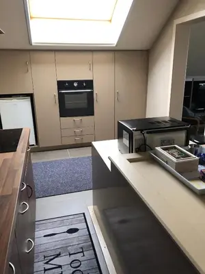 a kitchen with a stove and a microwave in it at Gastenverblijf 't Princenhuis in Vechmaal