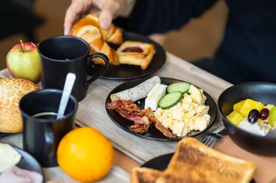 a table topped with plates of food and toast at B&B HOTEL Liège Rocourt in Liège