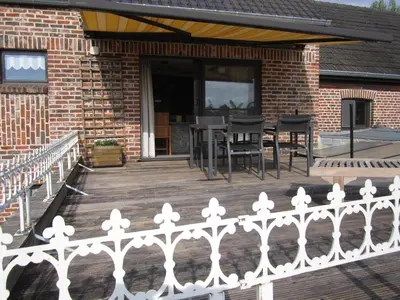 a porch with a white fence and a table and chairs at Vakantiewoning Upstairzzz in Kortessem