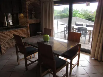 a dining room with a table and chairs and a fireplace at Vakantiewoning Upstairzzz in Kortessem
