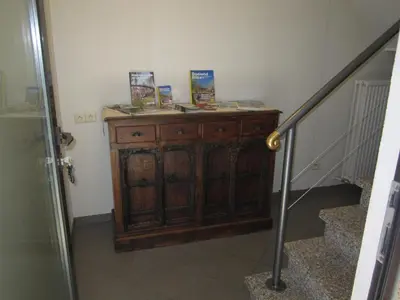 a room with a wooden cabinet with books on it at Vakantiewoning Upstairzzz in Kortessem