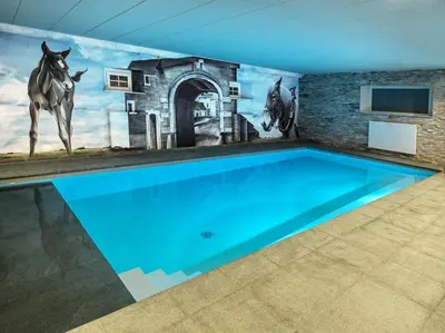 a swimming pool with a mural of horses on the wall at B&B Hoeve De Brieser in Heers