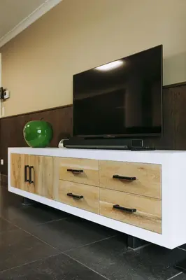 a flat screen tv on top of a white entertainment center at Vakantiewoning Vennekens in Peer