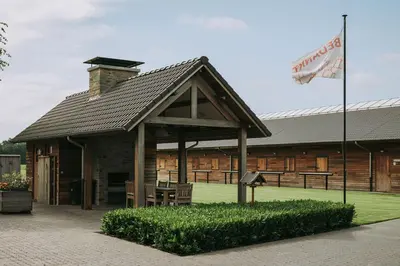 a building with a pavilion with tables and a flag at Vakantiewoning Vennekens in Peer