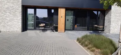 a patio with tables and chairs in a building at De Konik in Uikhoven