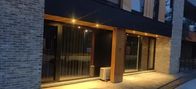 a building with glass doors on the side of it at De Konik in Uikhoven