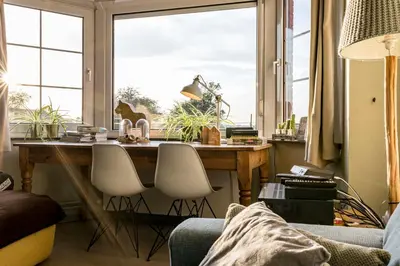 a room with a desk with chairs and a window at ZussEnzo - STOER FAMILIEHUIS - 18P - 5SLPK - GROTE TUIN - SAUNA - OFYR BBQ - HOMECINEMA - 15MIN MAASTRICHT in Zussen