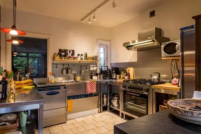 a large kitchen with stainless steel appliances at ZussEnzo - STOER FAMILIEHUIS - 18P - 5SLPK - GROTE TUIN - SAUNA - OFYR BBQ - HOMECINEMA - 15MIN MAASTRICHT in Zussen