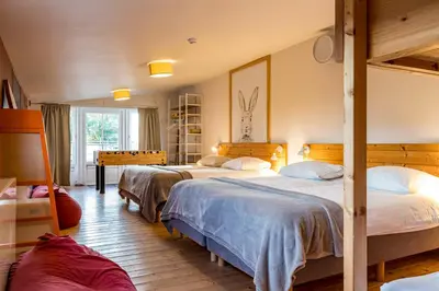 a bedroom with two beds in a room at ZussEnzo - STOER FAMILIEHUIS - 18P - 5SLPK - GROTE TUIN - SAUNA - OFYR BBQ - HOMECINEMA - 15MIN MAASTRICHT in Zussen