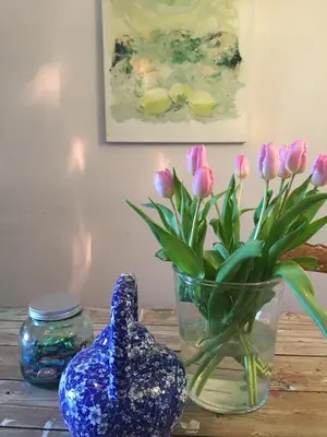a blue vase sitting next to a vase with pink flowers at PuurTeuven B&B tussen Kunst en Natuur in Voeren