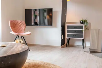 a living room with a chair and a dresser at Time-Out Zussen in Riemst